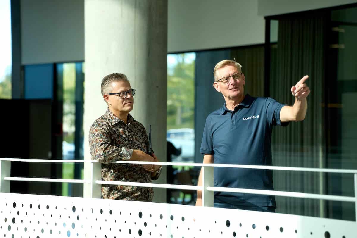 To medarbejdere fra Connexa, der står på en kontorgang og taler sammen om Virtualisering og backup til SMV'er